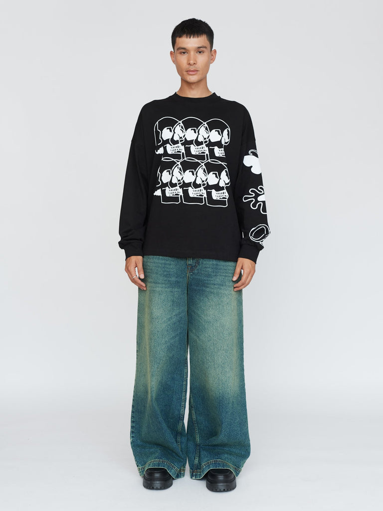 Black long-sleeve graphic T-shirt styled with loose faded jeans